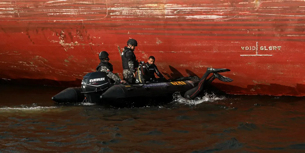 Members of Ecuador’s Special Mobile Anti-narcotics Group inspect the underside of a cargo ship in Guayaquil.