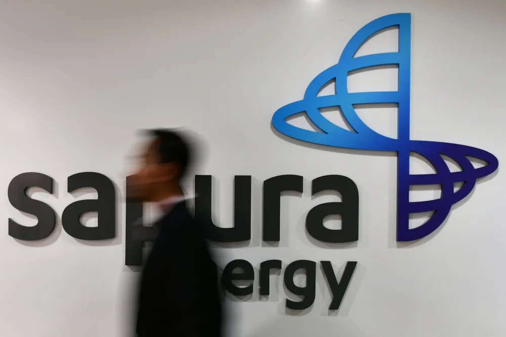 An employee walks past Sapura Energy's logo at its headquarters in Kuala Lumpur, Malaysia, in September 2018.