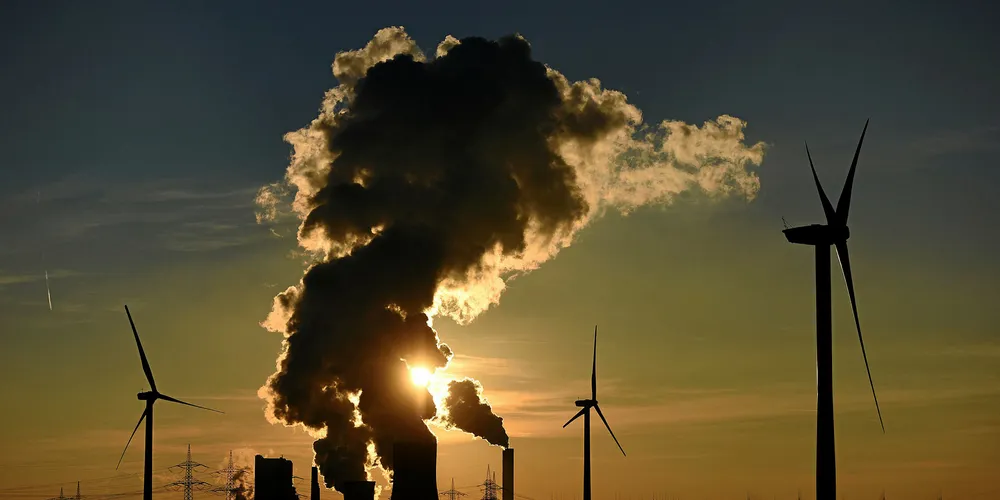 Electricity pylons and wind turbines stand beside the RWE Niederaussem coal-fired power plant near Bergheim, Germany.