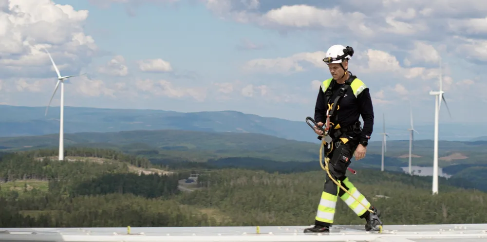 . En ansatt fra Akershus Energi Vind på toppen av en turbin på Engerfjellet, Odal Vindkraftverk.