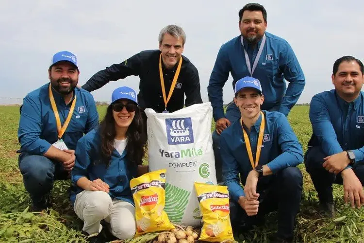The team from Yara, PepsiCo and affiliated potato farms pose with the fertilisers and end-product of potato crisps