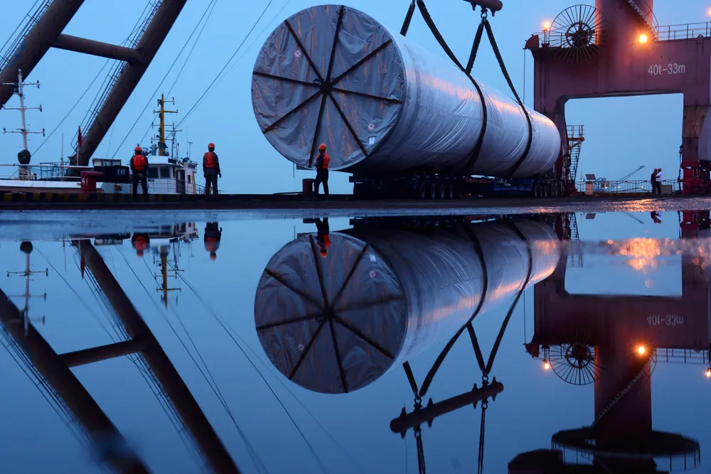 Wind buildout: workers are seen near a crane lifting offshore wind energy equipment by China Construction Industrial & Energy Engineering at a port in Nanjing, Jiangsu province