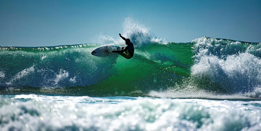 A surfer rides a wave in the French Atlantic Ocean