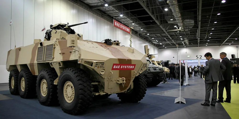 Visitors look at a BAE Systems RG41 combat vehicle on display at the Defence and Security Exhibition in London, England.