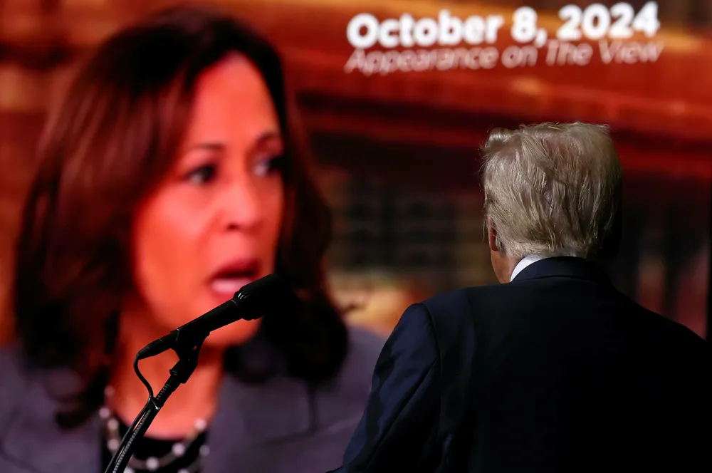 Republican presidential nominee, former U.S. President Donald Trump, watches a video featuring US Vice President Kamala Harris during a campaign rally.