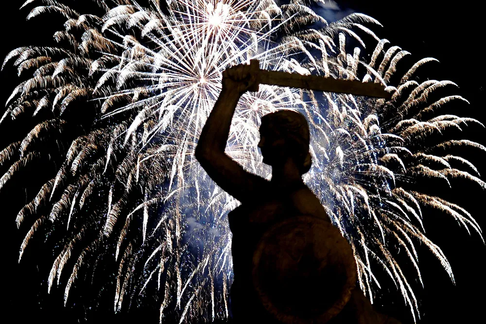 Celebration: fireworks explode behind the statue of the Mermaid during a show in the Polish capital of Warsaw
