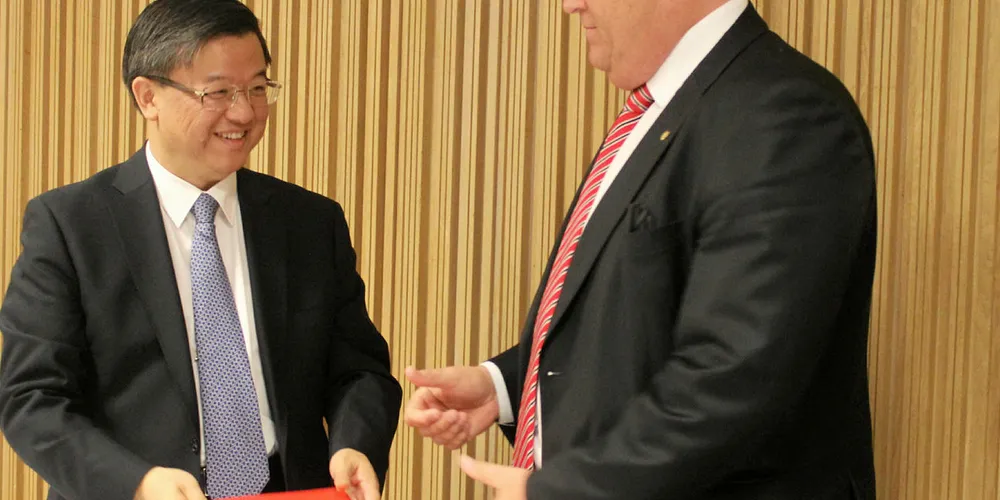 China's Customs and Veterinary Minister Ni Yuefeng (left) and Norway's Minister of fisheries Harald Tom Nesvik sign new salmon protocol.