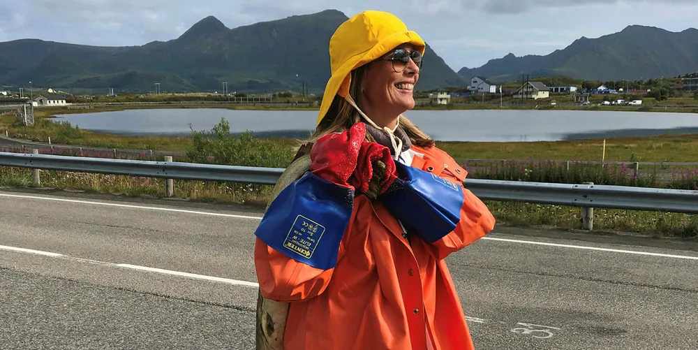 TORSKEN PÅ RYGGEN: Camilla Beck Sætre med torsk på ryggen under Arctic Race of Norway 2019. Sykkelrittet skulle passera vegkrysset rett ved Lofoten-fabrikken på Leknes i Lofoten.