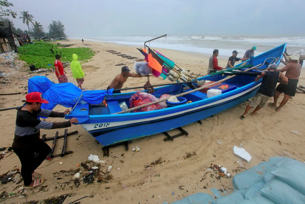 Pushing ahead: men move a fishing boat in Songkhla, Thailand