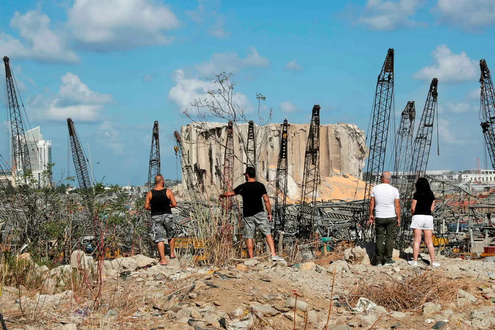 Lebanese people look at the devastated port of Beirut, the site of the explosion which killed at least 154 people and devastated swathes of the capital, in Beirut on August 9, 2020. (Photo by ANWAR AMRO / european afp / AFP)