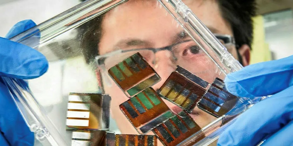 NREL researcher Mengjin Yang examines hybrid perovskite solar cells in his lab