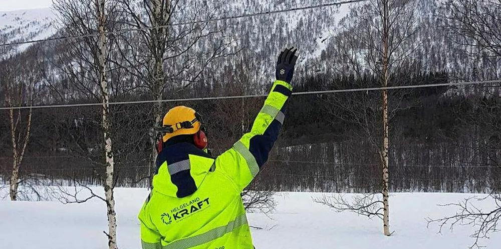 Store snømengder, gjør at kraftlinjene kommer langt ned mot bakken, som her illustrert av en ansatt hos Helgeland Kraft. I tillegg til store snømengder, har også uvær gjort hverdagen utfordrende for kraftselskapene i nord.