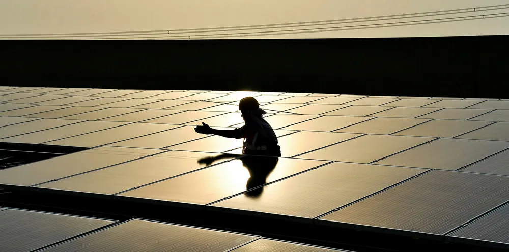 An Indian labourer installs solar panels at a site in Greater Noida, some 45km east of the capital New Delhi.