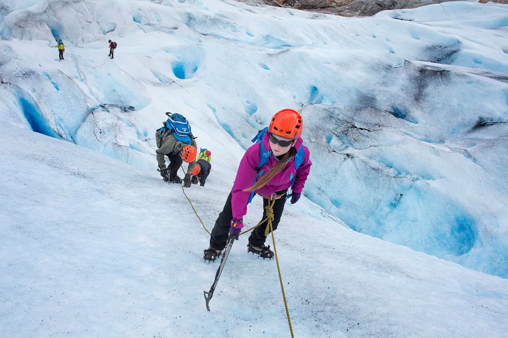 Birthe Norbotten står øverst i isveggen mens faren Rune og søsteren Bolette står lenger ned sammen med Øyvind Gjersvik fra Meløy Adventure som guider gruppen. Foto: Thomas Kleiven
