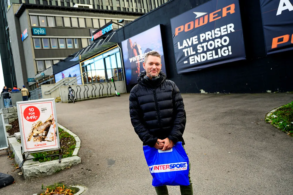 Espen Voll, fotografert utenfor intersport på Storo. Sportskjedene har hatt store varelager som de har solgt unna over en lang periode. Sitater fra Espen Voll. -I dag har jeg kjøpt et par sokker og en genser. - Jeg et litt bevisst på pris, men er det noe jeg liker så er det ikke så nøye. Har du lagt merke til salget av varelager fra de ulike sportskjedene. Ja, men det var ikke det her nå. G-Max var jo her tidligere, men det virker som det er samme butikk, samme varene ser det ut til. Foto: Fartein Rudjord
