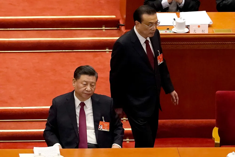 Ledelsen i det kinesiske kommunistpartiet satt uten munnbind, på første rekke, da Folkekongressen åpnet i Beijing fredag morgen. Statsminister Li Keqiang passerer president Xi Jinping på vei til talerstolen for å legge frem årets arbeidsrapport til nesten 3000 delegater – alle iført munnbind.