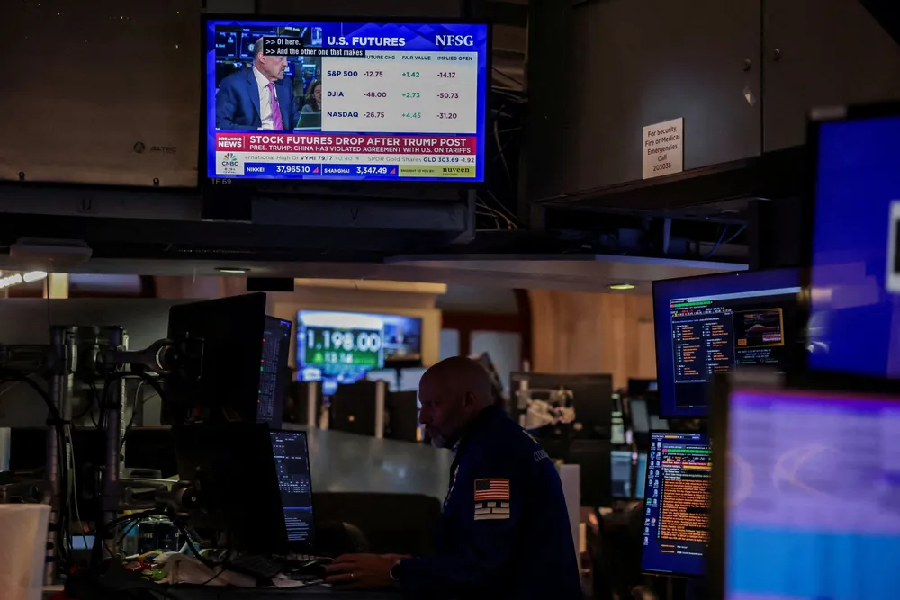 A screen shows “STOCK FUTURE DROP AFTER TRUMP POST” as a trader works on the floor at the New York Stock Exchange (NYSE) in New York City, U.S., May 30, 2025. REUTERS/Jeenah Moon