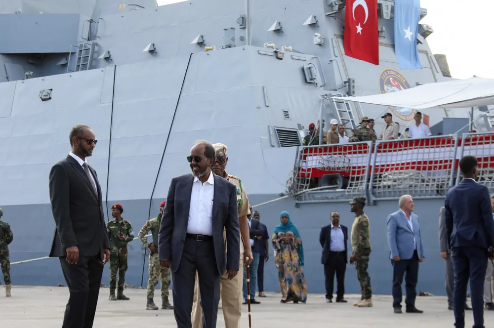 Somalia President Hassan Sheikh Mohamud (centre) and Minister of Defence Abdulkadir Mohamed Nur (left) walk near a Turkish naval vessel that docked in Mogadishu in late April.