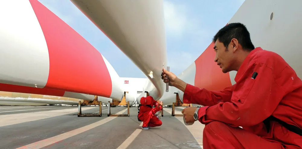 Labourers check the quality of blades of wind turbines in a factory in Lianyungang, east China's Jiangsu province.