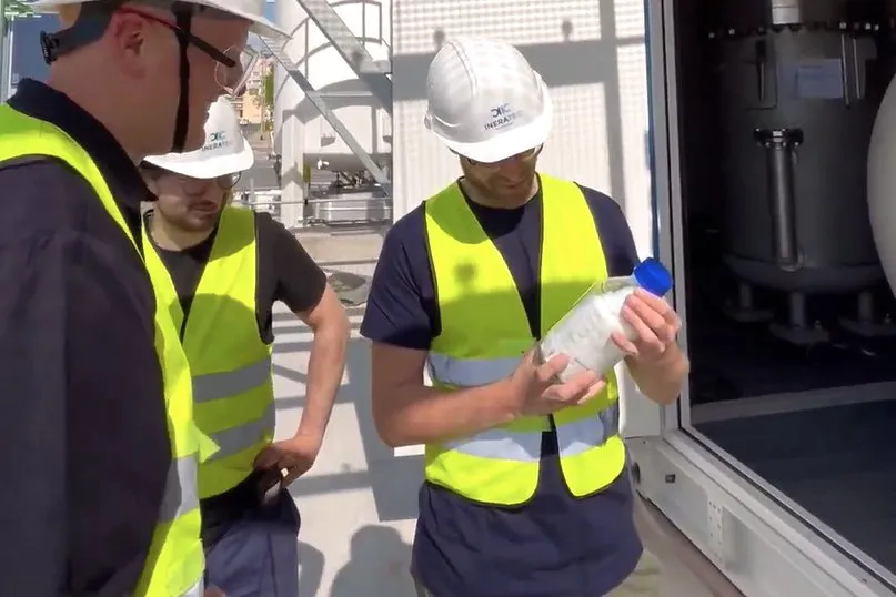 Ineratec employees examining the plant's first output of 'FT-Crude'.