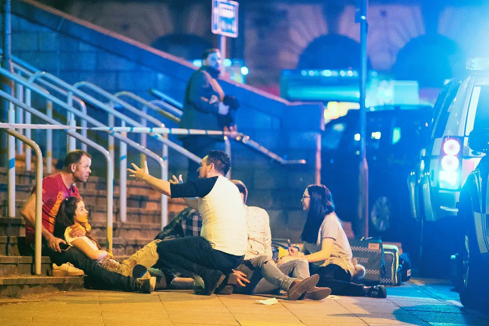 Sjokkerte publikummere blir tatt hånd om etter en eksplosjonen mot slutten av en konsert med Ariana Grande i Manchester Arena mandag kveld. Foto: Goodman/LNP/REX/Shutterstock/NTB Scanpix