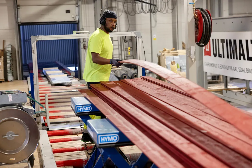 Produksjonsarbeider Robiel Zemichael pakker ferdig malte trevarer til kunder på G3 Gausdal Treindustriers anlegg i Gausdal.