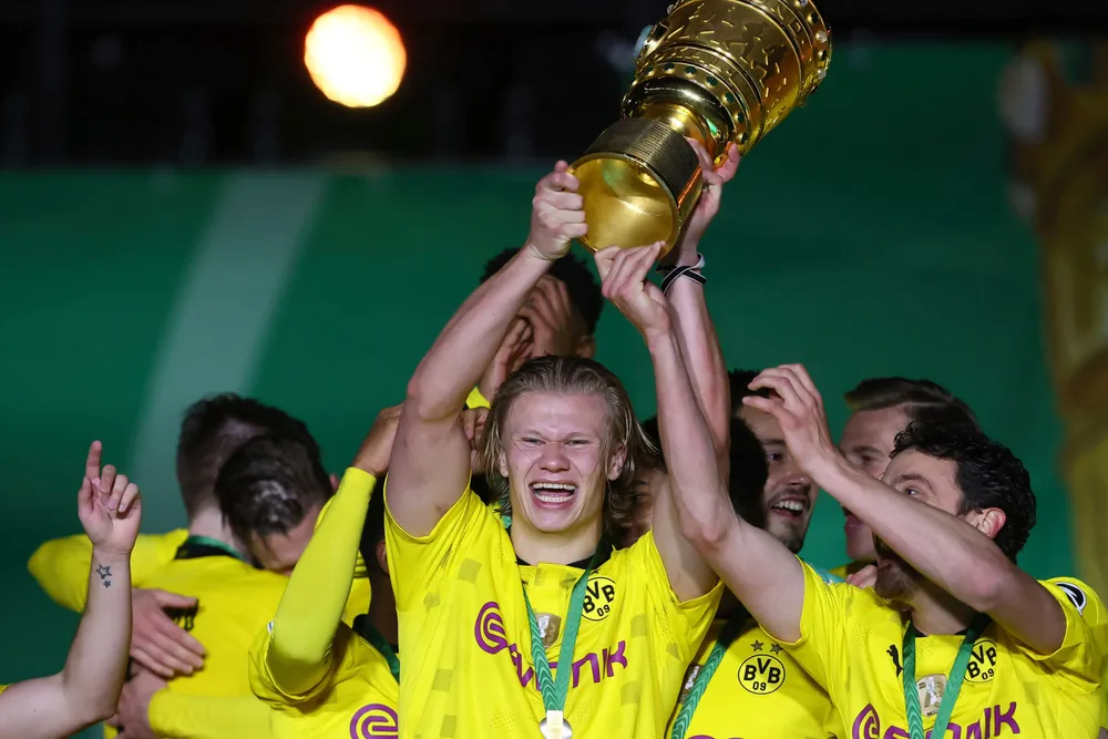 Svak krone gir norske klubber bedre priser når spillere selges – prisene settes i euro eller dollar, skriver artikkelforfatterne. Her feirer norske Erling Braut Haaland seieren i den tyske cupen med laget Dortmund.
