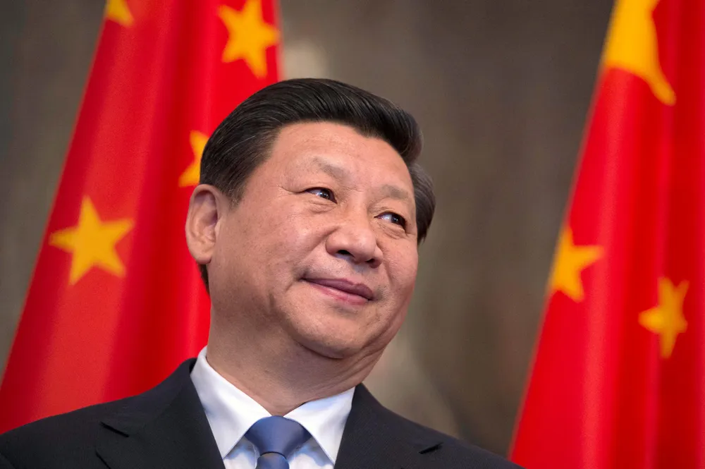 President Xi Jinping in front of Chinese flags.