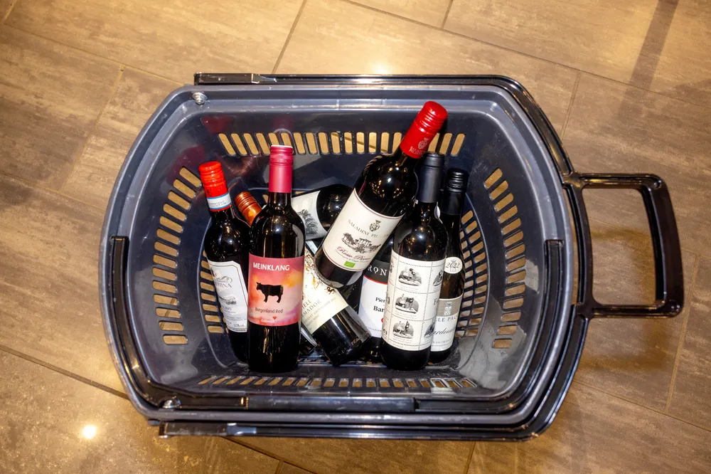 Illustrasjonsbilde som viser flasker i en handlekurv på Vinmonopolet. Både i Norge og i Sverige er leveranser av vin – og brennevin rammet som følge av et omfattende hackingangrep mot logistikkselskapet Skanlog.