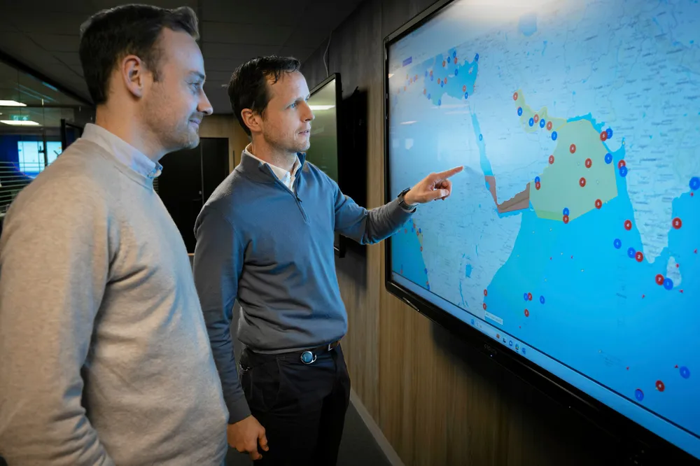 Lars Benjamin Vold (t.h) sammen med kollega Halvard Barstad. På kartet ser vi hvor ulike skip har befunnet seg når de blir utsatt.