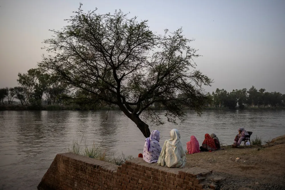 Residents sit near the Upper Chenab Canal during a heatwave in Sialkot, Pakistan.
