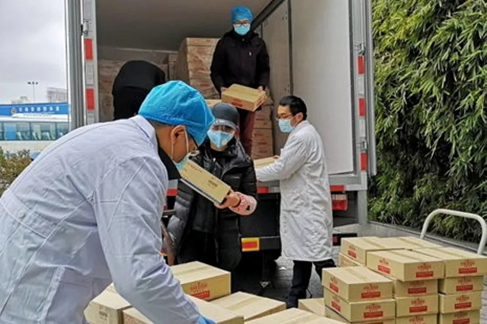 Employees from Thai Union China unload King Oscar products at a local hospital during the COVID-19 pandemic.