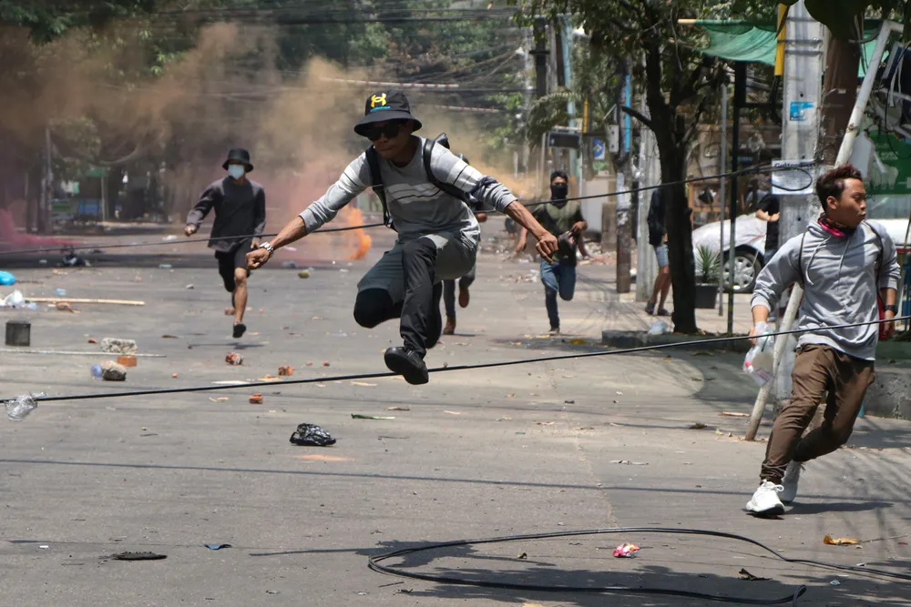 Heavy toll: anti-coup protesters run to avoid military forces during a demonstration in Yangon, Myanmar on 31 March