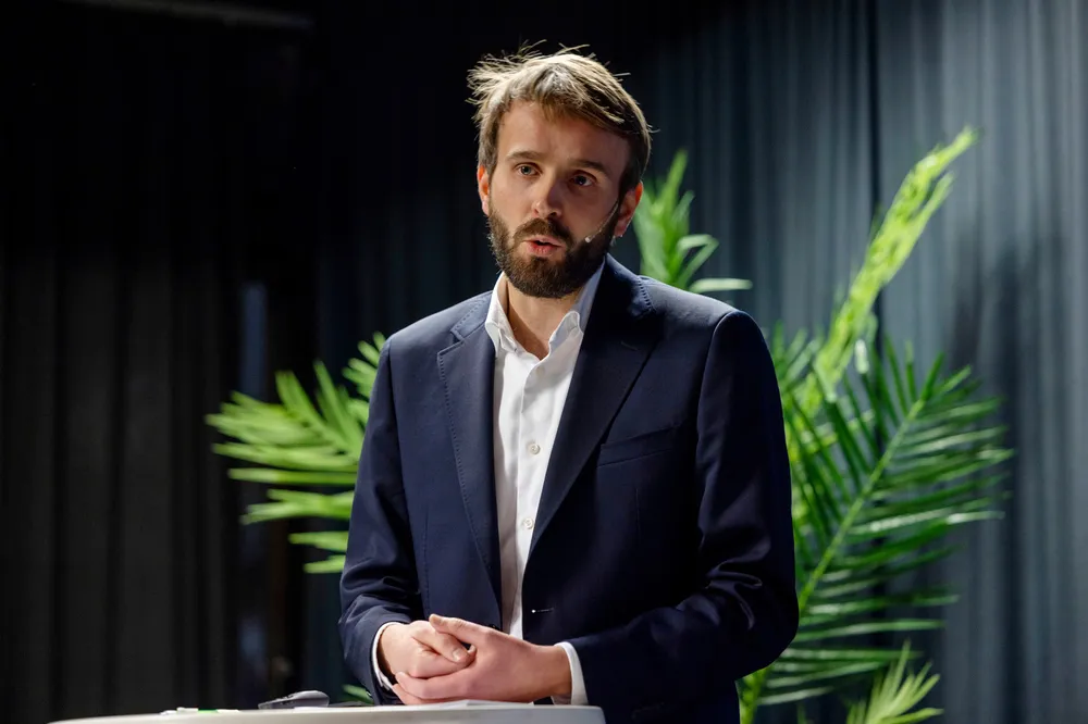 Det er rett før vi ser næringsminister Jan Christian Vestre med lilla Sigrun Berg-skjerf og fotformsko. Skjegget har han allerede, skriver artikkelforfatteren.