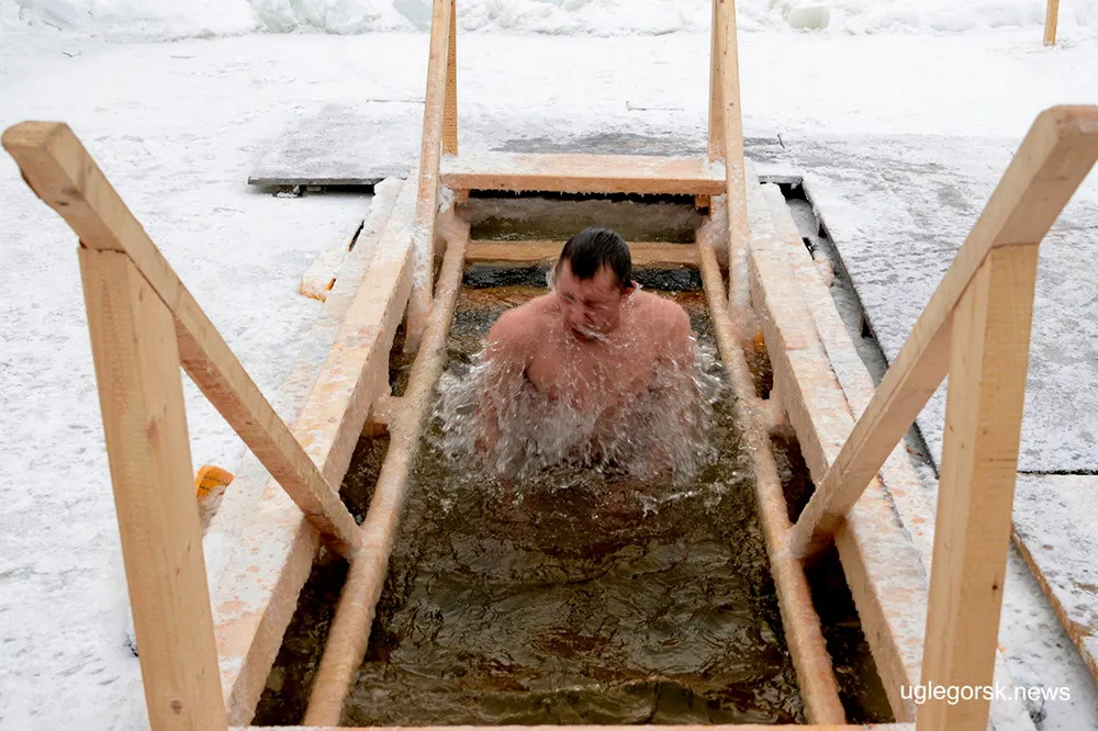 Defying obstacles: a pilgrim takes a dip in an ice hole on the Nadezhdinka river in Russia's Sakhalin Island