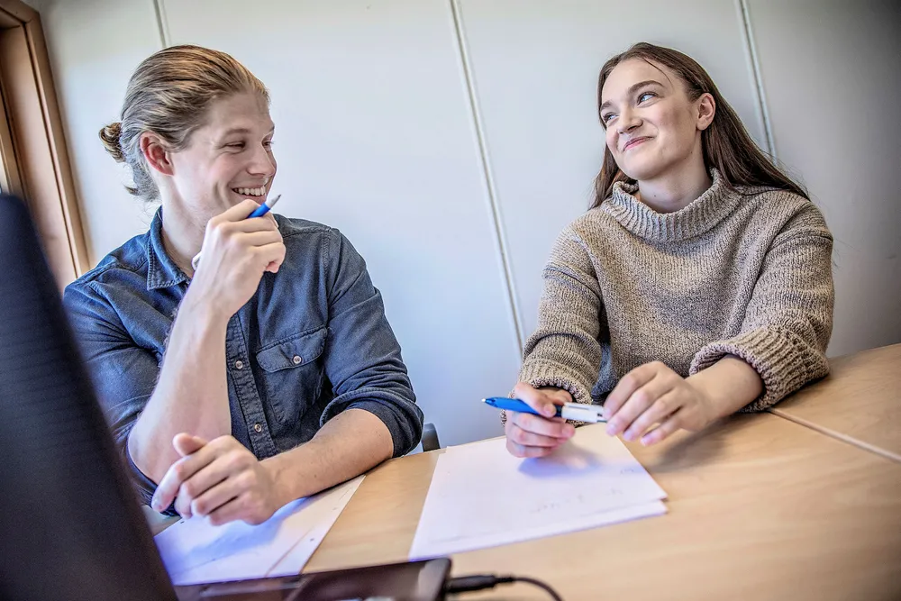 Nora Müller (til høyre) får mattehjelp av personlig leksehjelper Eirik Jerstad (25). Han studerer til lektor i realfag ved NTNU, og jobber deltid som personlig lærer via en formidlingstjeneste for privatundervisning og leksehjelp. – Når jeg mestrer faget, blir det også mye gøyere å holde på med, sier Müller. Foto: Øyvind Nordahl Næss