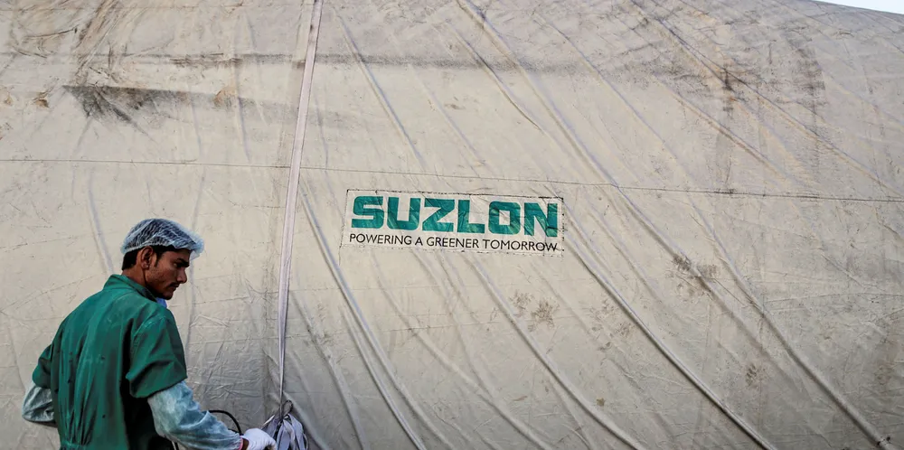 The Suzlon Energy Ltd. logo is displayed on a wind turbine blade cover at the company's rotor blade manufacturing plant in Bhuj, India,