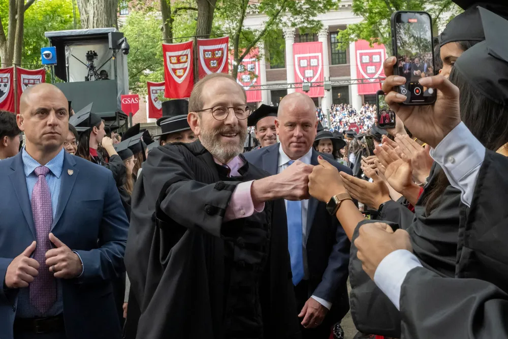Harvards president Alan Garber hilser på studenter ved studiestart.