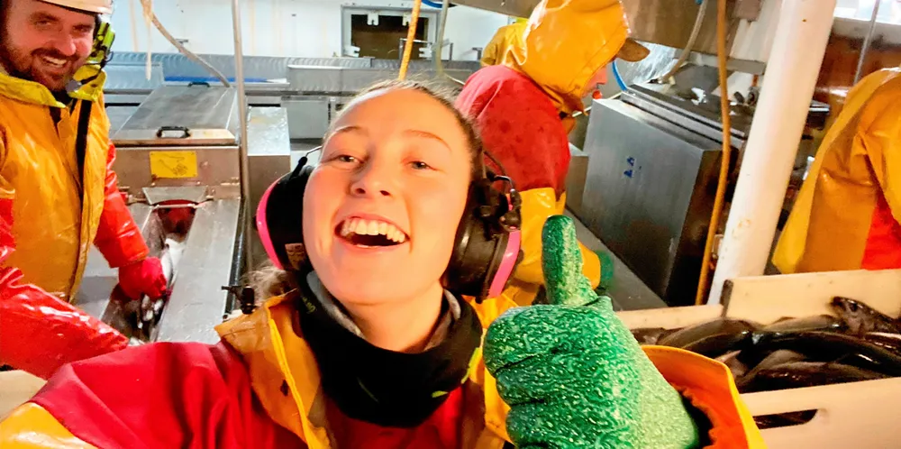 Linn Viola Østgaard i fabrikken på «Kamilla G» viser hvor fornøyd fiskerne er på kystfiskebåten for å ha passert 100 millioner i fangstinntekter i år.