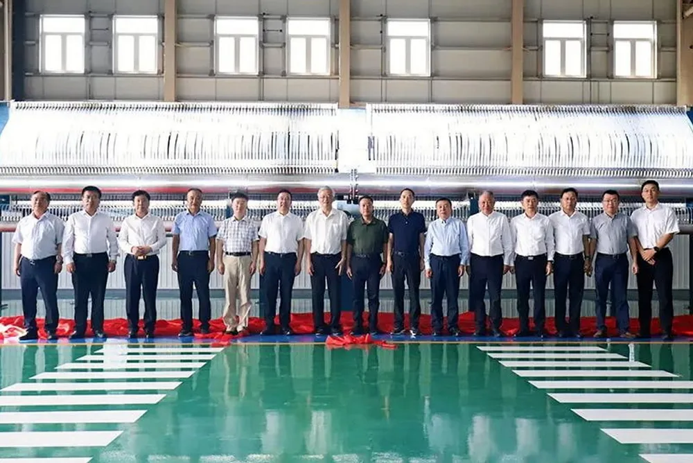 Local officials and executives pose in front of what appears to be the first electrolyser stack produced by Hongze Haijin.