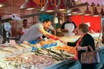 Kunde kjøper sjømat på fiskemarked på Sicilia i Italia.
