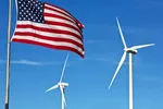 An American flag with two wind turbines