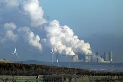 Wind turbines in front of a coal-fired power plant in Neurath, western Germany.