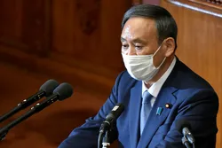 Japan's Prime Minister Yoshihide Suga wearing a face mask, gives his policy speech during an extraordinary session at the lower house of parliament in Tokyo on October 26, 2020.
