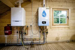An old central heating boiler (L) and a hydrogen boiler inside the Hydrogen Experience Centre in Apeldoorn, Netherlands, the hydrogen house of certification body Kiwa and Dutch gas, heat and power distributor Alliander